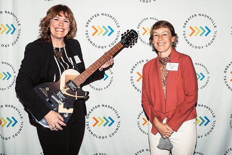 Middle Tennessee State University business intelligence and analytics professor Amy Harris, left, holds the signature guitar-themed award from the Greater Nashville Technology Council Diversity as winner of the Inclusion Advocate of the Year Award at the 12th Annual NTC Awards held in April from Stage Post Studios in Nashville, Tenn. At right is Lawrence Blank-Cook, managing director of technology at Deloitte, award sponsor. The 2021 awards ceremony was livestreamed as a hybrid in-person and virtual event. (Photo courtesy of Nathan Zucker)