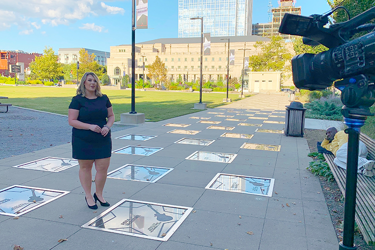 MTSU journalism student Christyn Allen of Oneida, Tennessee, records her introduction to a national award-winning 30-minute TV and web special, “100 Years of Broadcasting," last October at the Music City Walk of Fame in downtown Nashville as a curious spectator listens on a nearby bench. Allen, who graduated last December, was part of the nine-member MTSU School of Journalism and Strategic Media student team that created the project on the history of broadcasting in America with a Tennessee focus. (photo submitted)