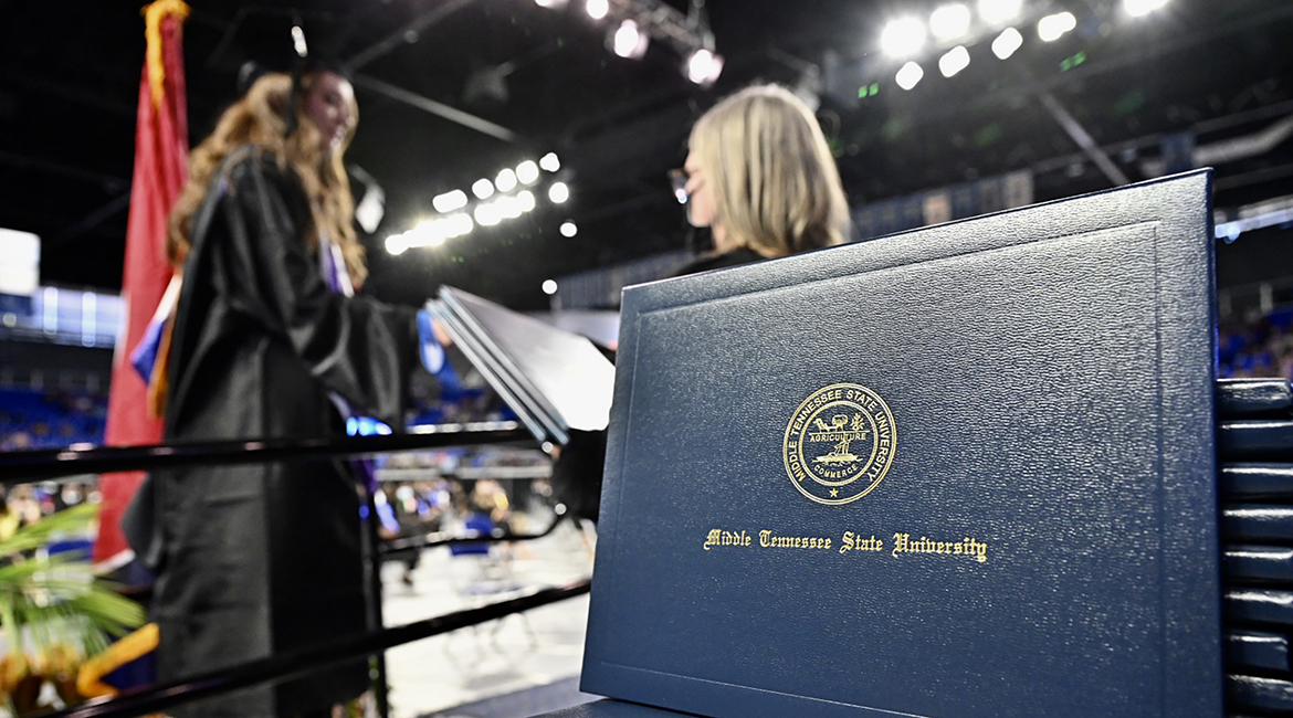 A stack of MTSU diploma covers awaits graduates as they cross the stage inside Murphy Center during the second day of the university's spring 2021 three-day weekend of commencement ceremonies in May in this file photo. Students will return to Murphy Center Saturday, Aug. 7, for the university's summer 2021 commencement ceremony. (MTSU file photo by J. Intintoli)
