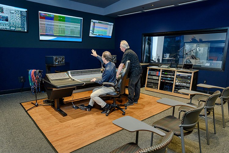 John Merchant, seated, chair of the Department of Recording Industry at Middle Tennessee State University, points out an option on the wall display screen to professor Dan Pfeifer in Studio D, one of the department's two newly relocated, customized, expandable recording facilities for students in the East Main Building on campus. Pfeifer is the co-chair of a committee overseeing the nearly $2 million project, which covers almost 5,000 square feet of recording space, control rooms, equipment rooms and an open gathering/reception area. (MTSU photo by J. Intintoli)
