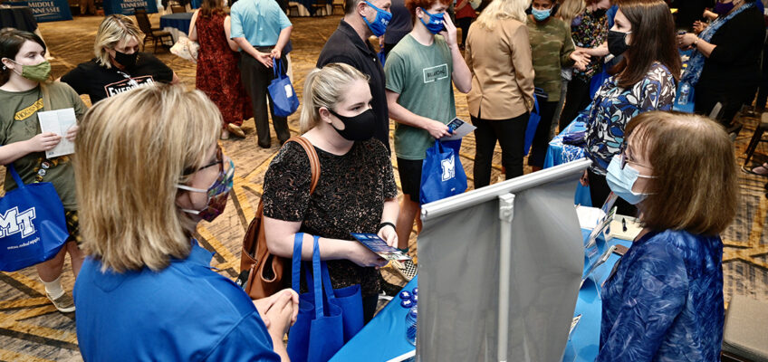 Courtney Lent, center, visits with one of MTSU’s academic colleges during the university’s True Blue Tour event recently at the Franklin Marriott Cool Springs. Lent, 32, will be returning as a student along with her stepson, Nathan Lent, 17, who will be a freshman in fall 2022, with plans to major in photography and minor in graphic design in the College of Liberal Arts. Courtney Lent plans to study psychology. She started at MTSU in 2007, but dropped out to enter the workforce. (MTSU photo by Andy Heidt)