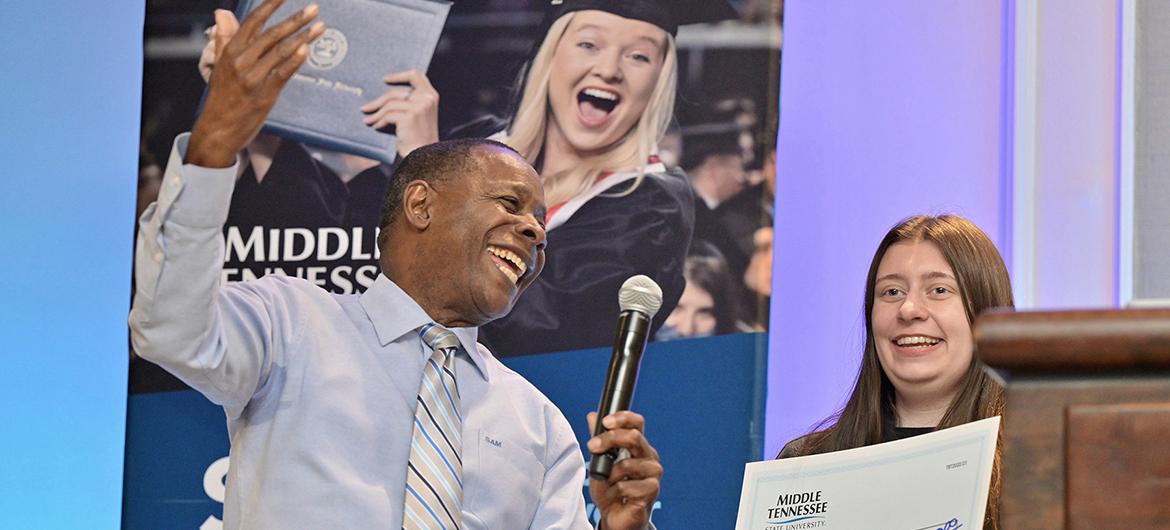 Middle Tennessee State University President Sidney A. McPhee, left, awards a prospective MTSU student a scholarship at the university’s True Blue Tour event at the Cool Springs Marriott in Franklin, Tenn., on Monday, Nov. 14, 2022. (MTSU photo by Andy Heidt)