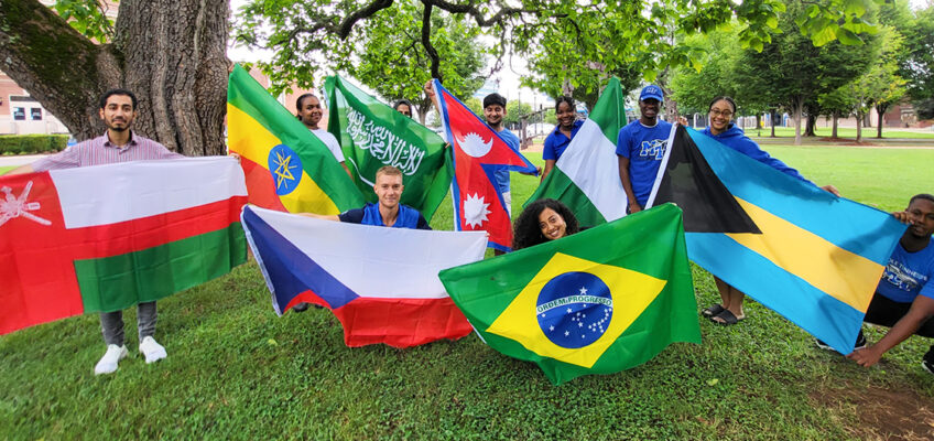 Pavel Motl, graduate student at Middle Tennessee State University and member of the International Student Council on campus, front row and center left, joins other members in holding up their countries’ flags at a council event in fall 2022 outside of the Jones Hall Building on campus. (Photo courtesy of Pavel Motl)