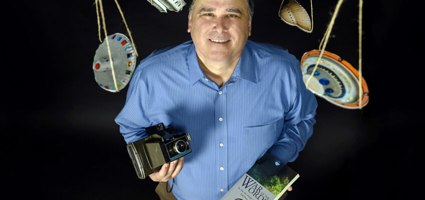 In this 2019 file photo, Craig Myers, Information and Technology Division editorial assistant and MTSU alumnus, holds a copy of his book, “War of the Words,” based on true events in Gulf Shores, Florida, surrounding UFO sighting and the debunking of a hoax when Myers was a newspaper reporter. His work led to his chapter contribution to a recently published book, “The Reliability of UFO Witness Testimony." (MTSU file photo by J. Intintoli)