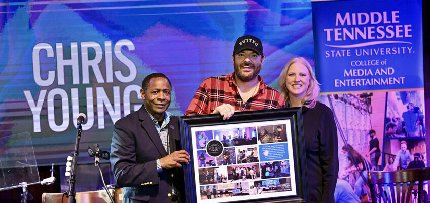 Middle Tennessee State University President Sidney A. McPhee, left, and Beverly Keel, dean of the College of Media and Entertainment, right, present country music superstar and alumnus Chris Young with a framed photo montage of students using the campus’ Chris Young Café during a special concert Feb. 7 at Blake Shelton’s Ole Red restaurant and live music venue in downtown Nashville, Tenn. (MTSU photo by James Cessna)