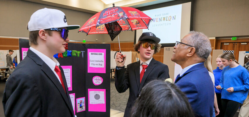 Middle Tennessee State University education professor Donald Snead, far right, listens to a student presentation at the inaugural Middle School Invention Convention in the Student Union Ballroom on Feb. 27, 2024. The middle school event is an offshoot of the annual Invention Convention put on by the College of Education the past three decades to bring students to campus from across the Midstate to showcase their range of creative, innovative inventions with the campus community. (MTSU photo by Andy Heidt)