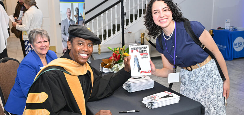 Internationally known educator, author and keynote speaker Adolph “Doc” Brown, left, presents an attendee with a signed copy of his book, “Championship Habits,” following Middle Tennessee State University’s 2024 Leadership Summit hosted Oct. 25 by the Jones College of Business at the Stones River Country Club in Murfreesboro, Tenn. Seated behind Brown is Jones College Dean Joyce Heames. (MTSU photo by James Cessna)