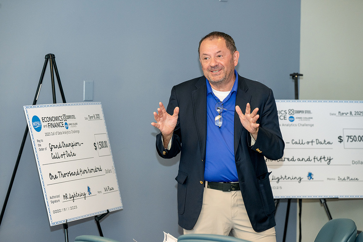 Stuart Fowler, chair of the Department of Economics and Finance at Middle Tennessee State University in Murfreesboro, Tenn., stands in front of the scholarship checks that would be awarded to first- and second-place student teams participating in “The Call of Data” 24-hour analytics challenge held Nov. 7-8 inside the Business and Aerospace Building. (MTSU photo by Andy Heidt)