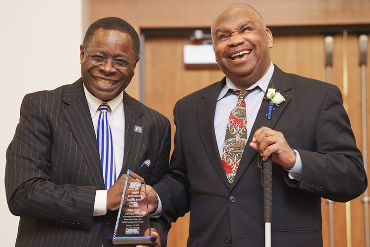 MTSU President Sidney A. McPhee, left, and John Harris, founding director of the university’s Disability and Access Center, laugh together Feb. 15, 2018, during the Unity Luncheon. Harris, an MTSU alumnus who retired in 2013 from his post after more than 27 years establishing and expanding services for students with disabilities, was one of six local residents honored at the 2018 event as “unsung heroes” serving the community. (MTSU file photo by Andy Heidt)