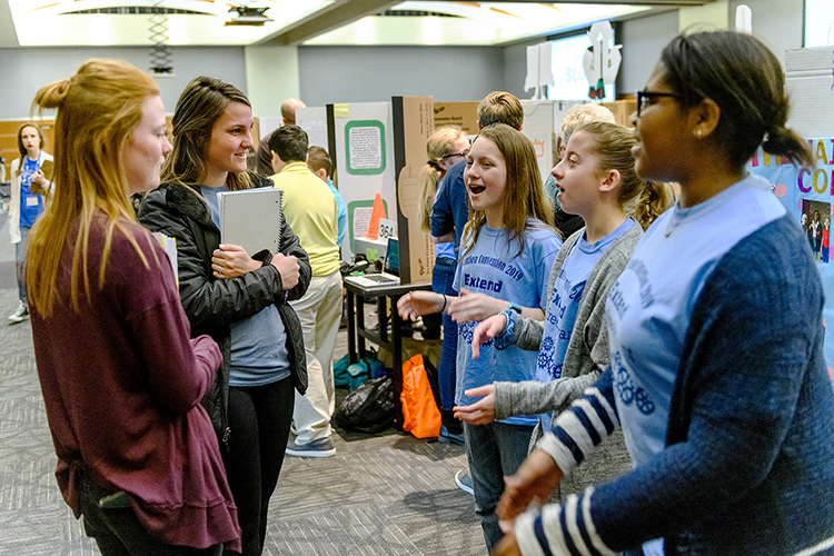 MTSU students Megan Cantrell, left, and Alyson Sledge talk to “Hairbrush Collector” inventors Piper Christman, center, Layla Tate, and Bailey Marshall from Winfree Bryant Middle School in Lebanon, Tenn., Feb. 21 during MTSU’s 27th annual Invention Convention. The girls’ invention won a ribbon as a “Judges’ Favorite” in the Sixth Grade “Make Life Easier” category. (MTSU photo by J. Intintoli)