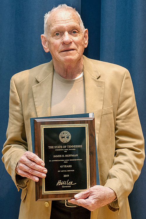 MTSU professor James O. "Jim" Huffman of Murfreesboro, chair of the Womack Department of Educational Leadership in the university's College of Education, poses with a plaque recognizing his 45 years of service to the university. Huffman, who joined the university faculty in 1974, was among more than 230 faculty and staff members at MTSU recognized for their years of service at the university’s annual Service Award Luncheon, held Dec. 5 in the James Union Building. (MTSU photo by James Cessna)