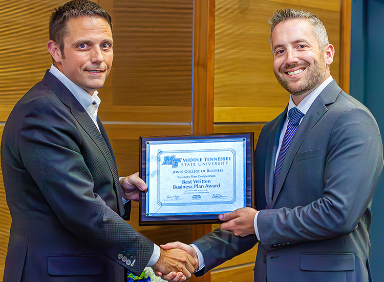2023 MTSU Business Plan Competition second-place winner Cory Sherman accepts the best written business plan plaque from Joshua Aaron, chairholder of the Wright Chair of Entrepreneurship and competition organizer, at the competition finals held April 26 in the Student Union Parliamentary Room at Middle Tennessee State University. Sherman earned $7,000 for his plan for Get Credentialed and an extra $500 for having the best written plan. (MTSU photo by Tom Beckwith)
