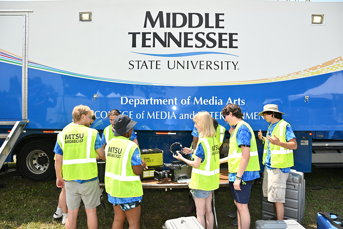 A small group of College of Media and Entertainment students from Middle Tennessee State University in Murfreesboro, Tenn., unpack and set up gear Wednesday, June 11, for the 2025 Bonnaroo Music and Arts Festival in Manchester, Tenn. In the background is “The Truck,” MTSU’s almost $2 million mobile production lab. The students are part of a team of about 50 students getting hands-on experience filming and livestreaming concerts at the four-day event. (MTSU photo by James Cessna)