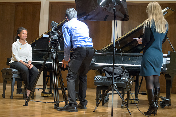 Chisha Nwobilor, left, a freshman majoring in music performance at MTSU, prepares to perform on one of the School of Music's Steinway grand pianos in Hinton Hall as part of a news story by WSMV-Channel 4 in this October 2012 file photo marking the school's first decade as an "All-Steinway School," the first in Tennessee. WSMV reporter/producer Adam Wurtzel, center, and Amber Holley, senior marketing consultant, conduct Nwobilor's interview. Nwobilor graduated cum laude with a bachelor's degree in music performance and with distinction from the University Honors College in 2016, then returned to MTSU to earn her master's degree in social work in 2018. The MTSU School of Music has planned a "Steinway Anniversary Celebration Concert" for Tuesday, April 4, at 7:30 p.m., featuring a “piano extravaganza” of performances by MTSU students, faculty and alumni. MTSU, which has 60 grand and upright Steinways, is marking its 20th anniversary as one of 200-plus "All-Steinway Schools" in the world with the concert. (MTSU file photo by J. Intintoli)