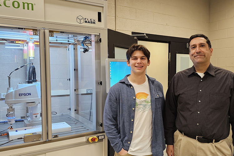 Middle Tennessee State University junior mechatronics engineering major Samuel Apigian of Murfreesboro, Tenn., left, and Engineering Technology lecturer Antonio Saavedra are pictured next to robotics equipment inside a Voorhees Engineering Technology laboratory earlier this semester on the MTSU campus. Apigian is heading to Germany this summer after being awarded the highly competitive DAAD RISE scholarship where he will be interning at Technische Universität Dresden. (MTSU photo by Robin E. Lee)