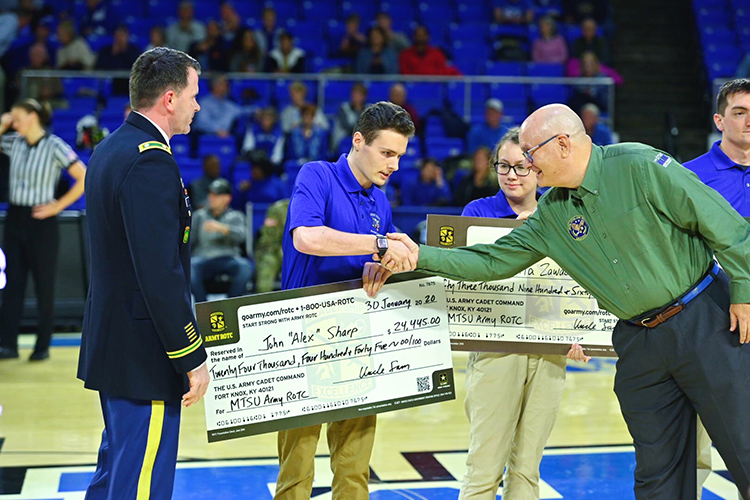 Andrew Oppmann, right, MTSU vice president for marketing and communications and Army Reserve ambassador, congratulates sophomore ROTC cadet John Sharp after the student received a Army Reserve scholarship during a special presentation Jan. 30 at the MTSU Women’s Basketball’s veteran appreciation night at Murphy Center. At far left is Army by Lt. Col. Carrick McCarthy, MTSU’s professor of military science and head of the Blue Raider Battalion. (MTSU photo by Cat Curtis Murphy)