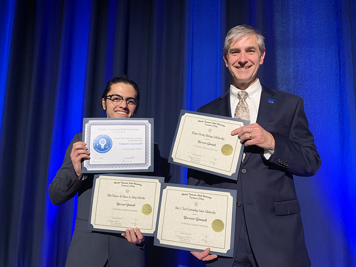 MTSU biology and psychology double major Yaseen Ginnab, left, of Nashville, Tenn., holds recognition for innovation and certificates for scholarships he has received from the College of Basic and Applied Sciences as Dean Greg Van Patten shares the moment earlier this spring. They are shown following the college’s awards ceremony in late April in the James Union Building. Ginnab also received the Goldwater Scholarship and is spending three months in Nova Scotia conducting research as part of a Fulbright Canada program. (MTSU photo by Randy Weiler)