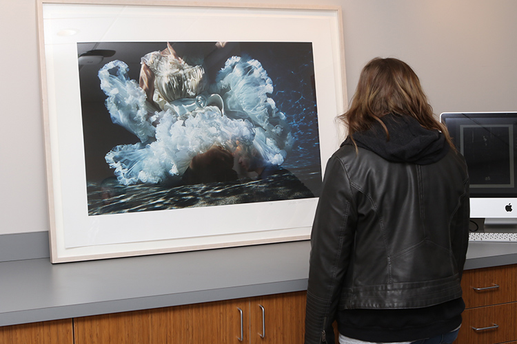 An attendee of the March 20 ribbon-cutting for the new Baldwin Photographic Collection and Archive view one of the prints on display in the archive’s reading room area on the second floor of the Miller Education Center on Bell Street. (MTSU photo by James Cessna)