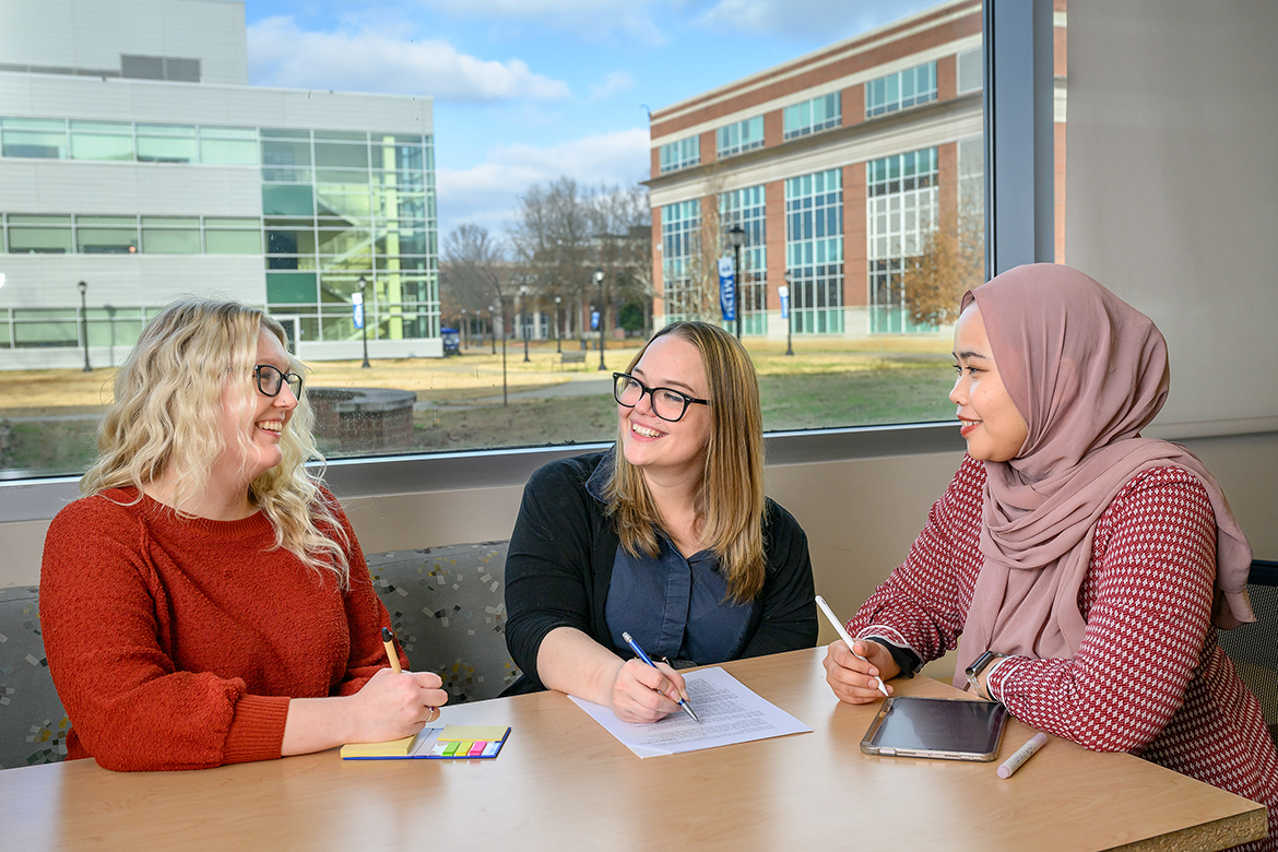 Middle Tennessee State University graduate student Alexa Summersill, left, researcher and biology assistant professor M. Elizabeth Barnes and doctoral student Rahmi Aini discuss the collection of data from thousands of biology students nationwide near the Social Perceptions of Science Lab in the Science Building on the MTSU campus in Murfreesboro, Tenn. The National Science Foundation-funded research involved conflict reducing practices in evolution education associated with increases in evolution acceptance. (MTSU photo by J. Intintoli)
