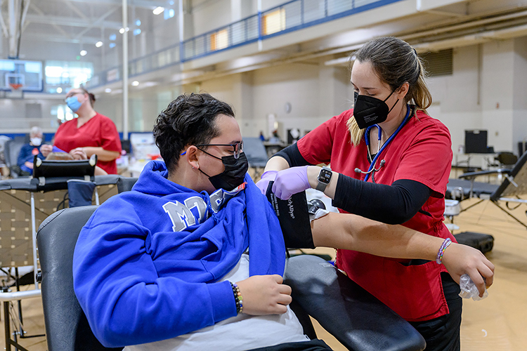 MTSU freshman Anthony Coronel, an information systems major from Oak Ridge, Tenn., watches as American Red Cross phlebotomist Kelsie Manuel performs a blood-pressure check in the Student Health, Wellness and Recreation Center Monday, Nov. 1, on the first day of MTSU's “True Blue Blood Drive." The annual drive continues Tuesday and Wednesday, Nov. 2 and 3, from 10 a.m. to 6 p.m. (MTSU photo by J. Intintoli)