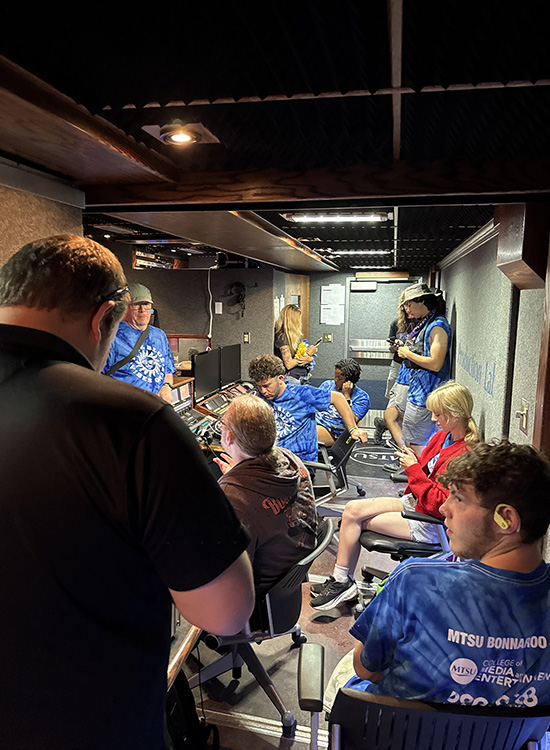 Some of the 50-member team from Middle Tennessee State University’s College of Media and Entertainment take shelter inside the mobile production lab, known as “The Truck,” on Friday night, June 13, at the four-day 2025 Bonnaroo Music and Arts in Manchester, Tenn. Organizers cancelled the event Friday night due to severe weather and additional forecasted rain through the weekend. (MTSU photo by Mike Forbes)