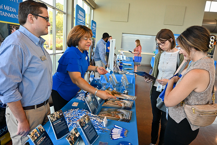 MTSU alumna Bethany Erb, center right, a school counselor at Montgomery Central High School in Clarksville, Tennessee, learns more about Middle Tennessee State University’s College of Media and Entertainment at the university’s True Blue Tour event on Wednesday, Sept. 28, 2022, at the Wilma Rudolph Event Center in Clarksville, Tennessee. (MTSU photo by Stephanie Wagner)