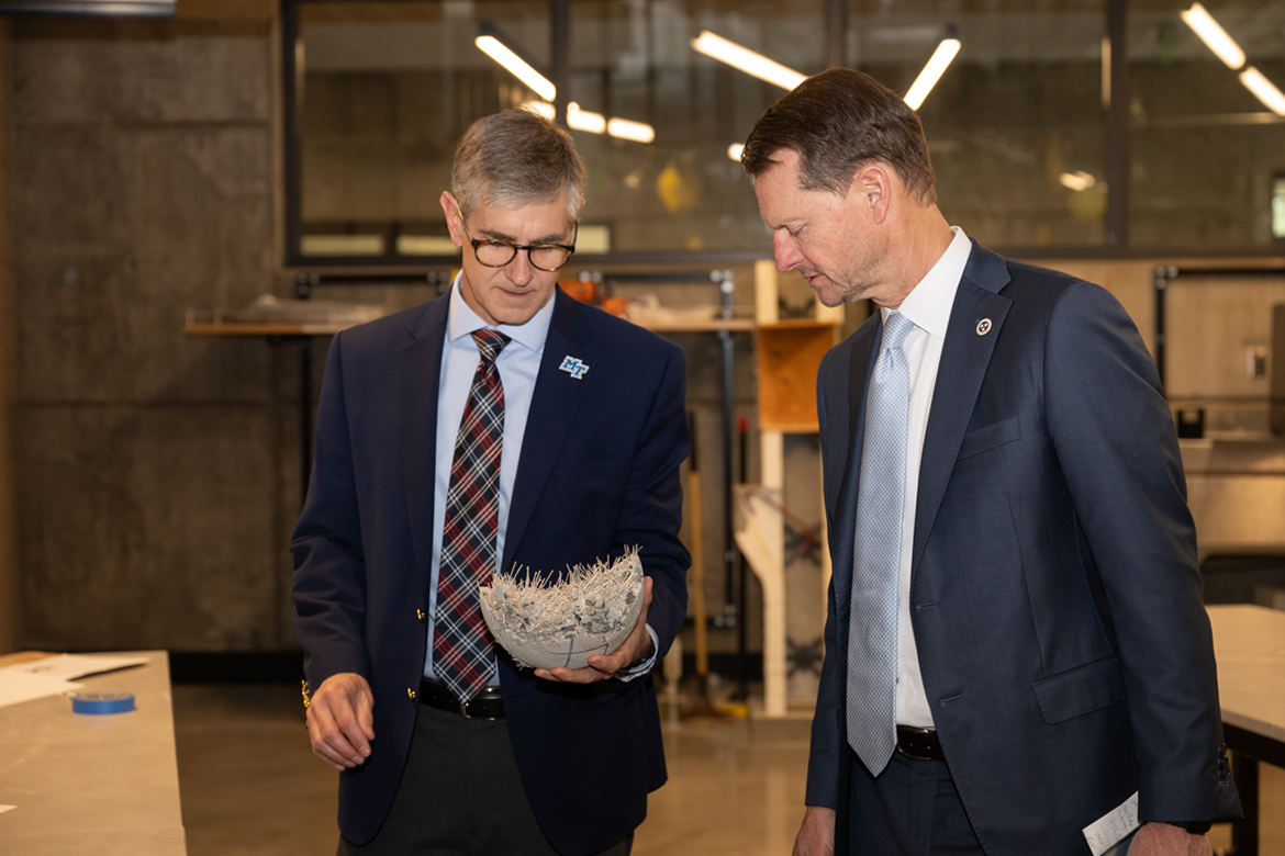 Middle Tennessee State University College of Basic and Applied Sciences Dean Greg Van Patten, left, and Stuart McWhorter, Tennessee Department of Economic Development commissioner, inspect the fiber material on the inside of a concrete bowling ball Wednesday, March 26, in an MTSU School of Concrete and Construction Management Building lab on campus in Murfreesboro, Tenn. Students take concrete bowling balls to national competitions. (MTSU photo by James Cessna)