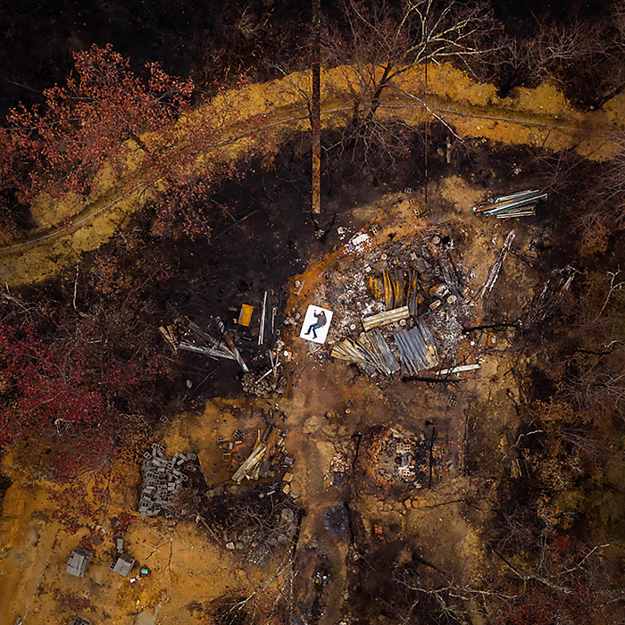 Kirk Fleta rests on a white mattress in the ashen ruins of his home, destroyed in the deadly 2016 wildfires that swept through portions of the Great Smoky Mountains, devastating Gatlinburg, Pigeon Forge and more than 10,000 acres of the national park in this aerial photo captured by MTSU alumnus and photographer/entrepreneur Jeremy Cowart for his "Voices of Gatlinburg" project. (Photo by Jeremy Cowart)