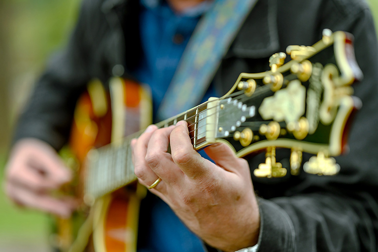 Professional musician and returning student Adam Davis, whose studying jazz in MTSU's Master of Music program, picks his guitar in Walnut Grove during the fall 2021 semester. (MTSU photo by J. Intintoli)