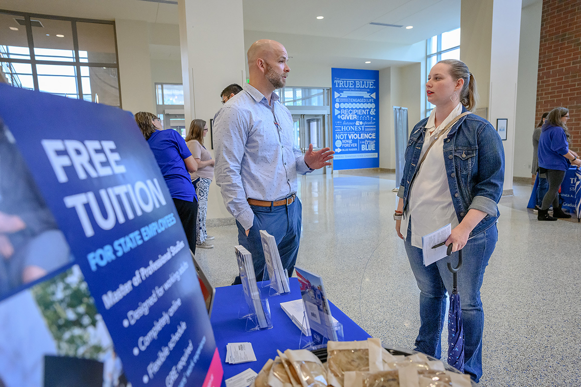 Matthew Duncan, chair, Middle Tennessee State University University Studies department, talks to Brielle Campos, University Studies assistant professor, about course offerings she might pursue while considering a graduate degree with a perk of free tuition for state employees. MTSU held a "Don't Leave Money on the Table" event Wednesday, July 19, in the Student Union first-floor atrium. (MTSU photo by J. Intintoli)
