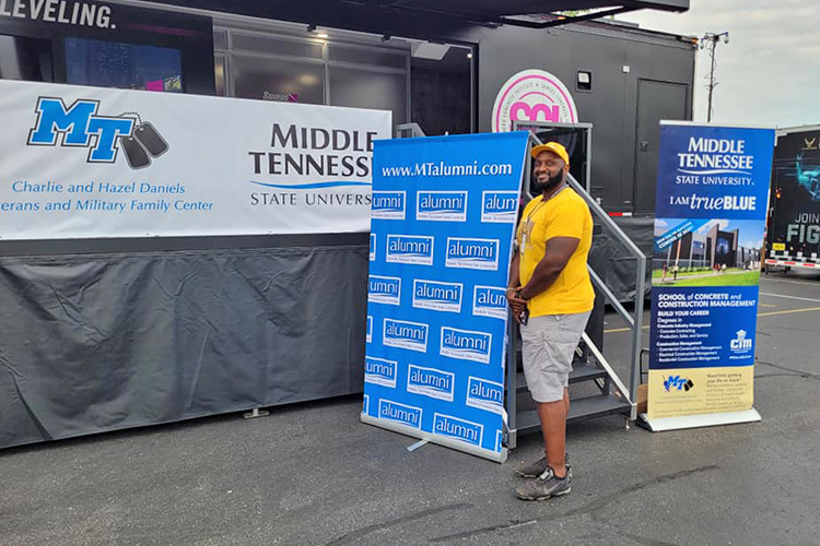 Middle Tennessee State University alumnus and former Blue Raider football player Germayle Franklin poses next to the MTSU hospitality area in August during the Big Machine Music City Grand Prix in Nashville, Tenn. Franklin operates Franklin’s Fruit Tea in Murfreesboro. He created his special tea while an undergraduate and now offers it on campus through Dwight’s Mini Mart in Keathley University Center. (Submitted photo)