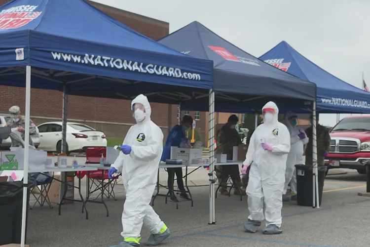 Covered in personal protective equipment, men and women prepare to administer COVID-19 tests to people in a drive-thru at Shelbyville (Tenn.) Central High School April 18. (Photo submitted)