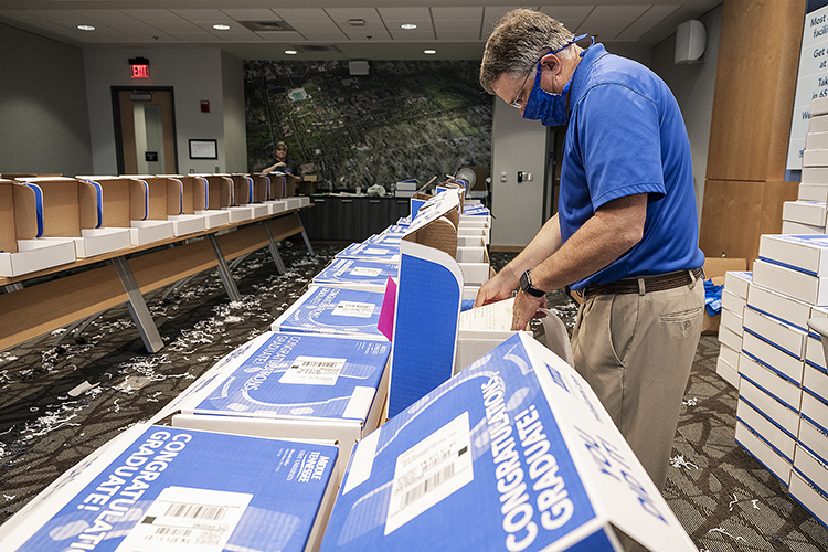 MTSU Provost Mark Byrnes pitches in with packing a True Blue Graduation Box for shipping to spring graduates Wednesday, May 20, inside the Student Services and Admissions Center. (MTSU photo by Andy Heidt)