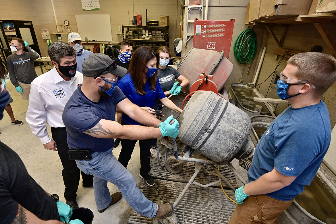 Big Machine Music City Grand Prix CEO and MTSU alumnus Matt Crews, left in white shirt, observes as MTSU Concrete Industry Management senior and Missouri native Cody Gange, center left, and lab assistant and senior T.J. Paul of Readyville, Tenn., right, assist concrete industry professor Heather Brown, center, with making an eco-friendly concrete mix inside a lab in the Voorhees Engineering Technology Building on the Murfreesboro, Tenn., campus in a November 2020 photo. The mix will be tested for use in race barriers for the Aug. 8 race in downtown Nashville. In the background, from left, are alumnus Denny Lind of Master Builders Solutions, and MTSU senior Concrete Industry Management majors Austin Gaydosh of Rockvale, Tenn., and Autumn Gates of Murfreesboro. Big Machine Music City Grand Prix has a formal partnership agreement with MTSU and its CIM program. (MTSU file photo by Andy Heidt)