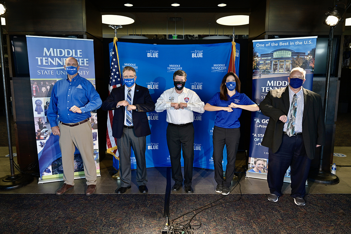 MTSU School of Concrete and Construction Director Kelly Strong, left, university Provost Mark Byrnes, Music City Grand Prix CEO Matt Crews, concrete professor Heather Brown and College of Basic and Applied Sciences Dean Bud Fischer celebrate the MOU agreement signing with an “elbow bump” Monday, Nov. 9, in the Jeff Hendrix Stadium Club at Floyd Stadium. Brown will help oversee students in the concrete program producing eco-friendly race barriers for the August 2021 race. (MTSU photo by Andy Heidt)
