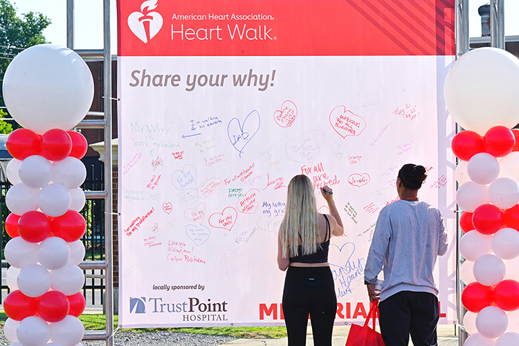 Participants in the 2021 Rutherford County Heart Walk write their reasons for walking to raise funding for heart disease research on a white board Sept. 25 at Dean A. Hayes Track and Soccer Stadium. (MTSU photo by Cat Curtis Murphy)