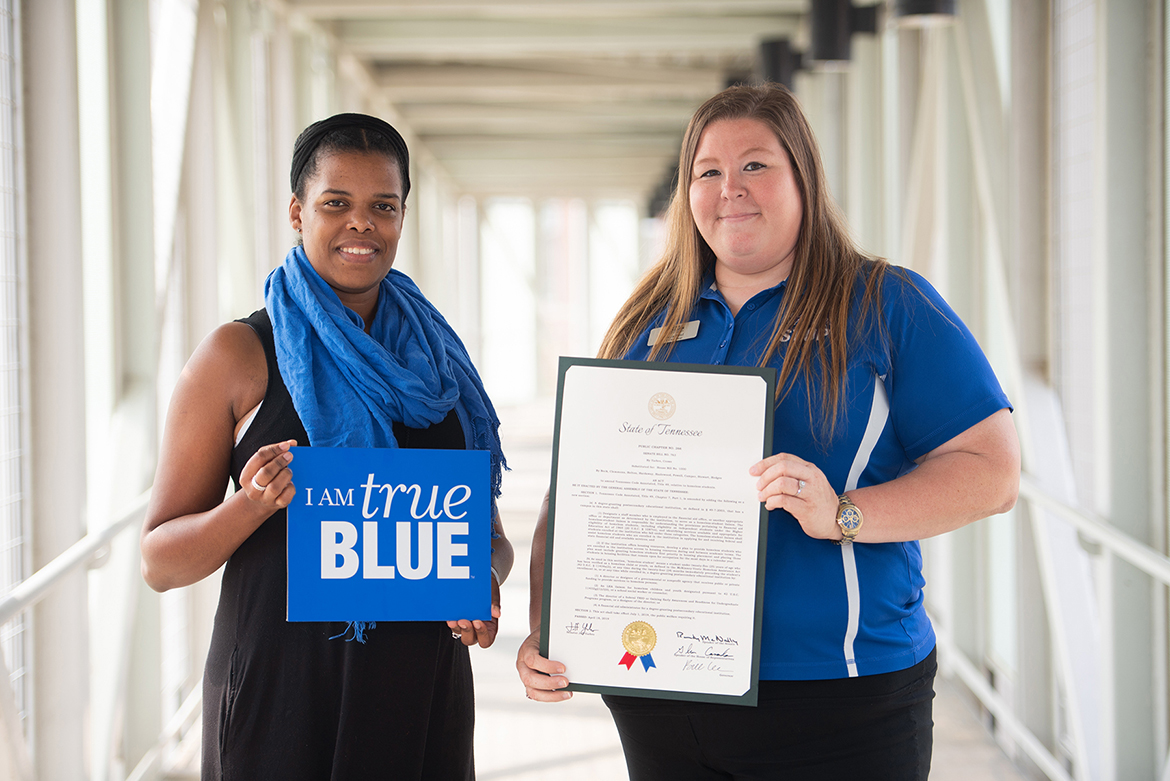 Becca Seul, right, associate director at MT One Stop at MTSU, holds a framed commemorative copy of the new state law to require state-supported colleges and universities to develop programs to help homeless students. Seul and Danielle Rochelle, left, coordinator of outreach and support programs for MT One Stop, testified at the state Capitol in Nashville, Tenn., in support of the bill when it was in committee. (MTSU photo by James Cessna)