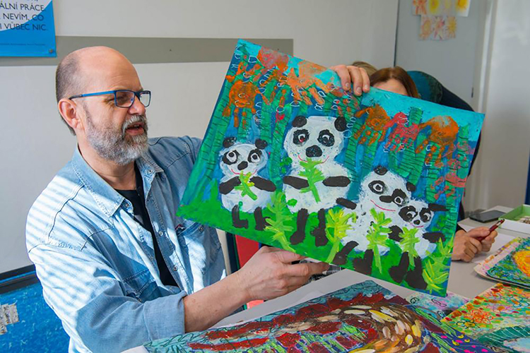 Visual artist Josef Zednik, chairman of the 48th International Children's Exhibition of Fine Arts Lidice panel of judges, examines one of more than 22,000 entries from 78 countries this spring in the 2020 competition for children ages 4 to 16 at the ICEFA headquarters in Lidice, Czech Republic. Students from the Tennessee School for the Blind in Nashville, guided by MTSU art education students, earned an honorable mention for their one-minute stop-motion animated video entry, "Arctic Blues." (Photo courtesy of ICEFA Lidice)