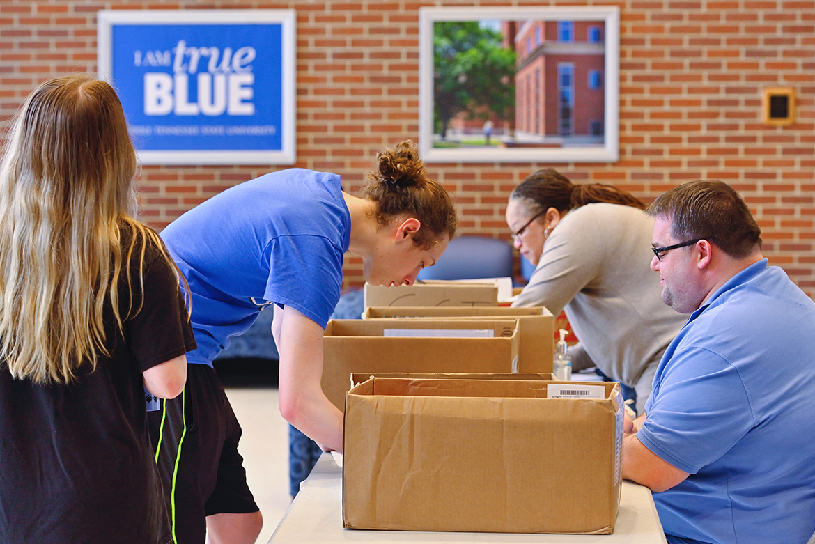 Staff with MTSU’s Information Technology Division helps students with laptop and internet hotspot checkouts recently in the Cope Administration Building lobby. ITD has been lending a limited supply of such technology to students who need it since the university moved to remote courses for the rest of the spring semester. (MTSU photo by Cat Curtis Murphy)