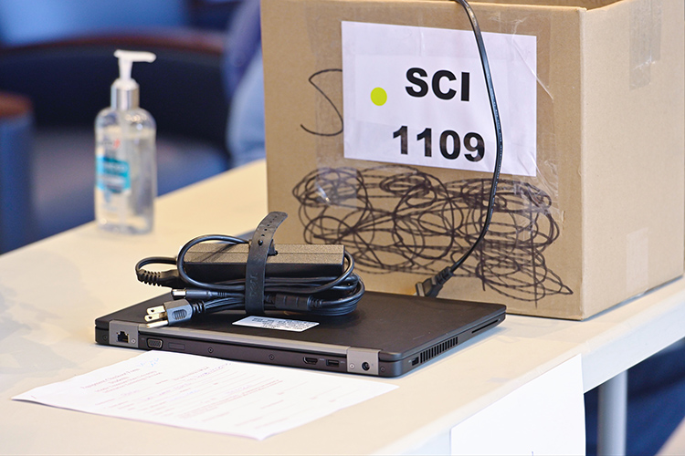 A laptop and charging cord await checkout recently in the Cope Administration Building lobby. MTSU’s Information Technology Division has been lending a limited supply of laptops and T-Mobile internet hotspots to students who need it since the university moved to remote courses for the rest of the spring semester. (MTSU photo by Cat Curtis Murphy)