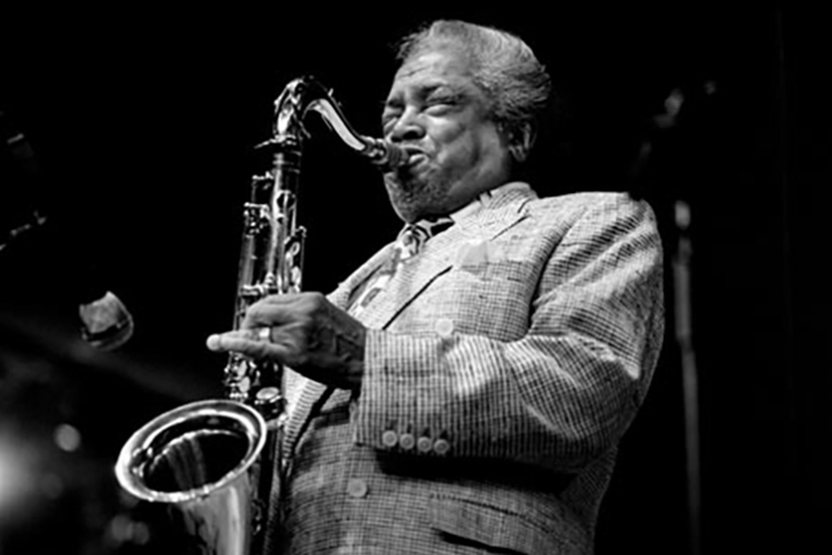 The late jazz tenor saxophonist Jean-Baptiste “Illinois” Jacquet, shown here at a 1998 concert at Brecon, Wales, is the focus at MTSU’s 2021 Illinois Jacquet Jazz Festival, set Saturday, April 10. (Photo by William Ellis)