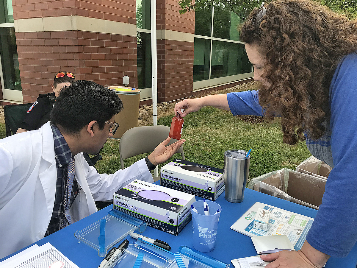 Lipscomb University College of Pharmacy second-year student Chintan Patel, left, and MTSU Campus Pharmacy pharmacist Tabby Ragland inspect the quantity of the medicine left inside the bottle dropped off Tuesday, April 23, during the MTSU Prescription Drug Take-Back Day. They collected more than 51 pounds of unwanted medications by the end of the event.