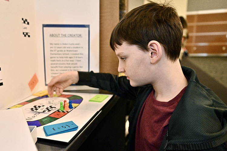 Watertown Elementary fifth grader Aiden Curtis inspects his "Quad Math Racing" game at the 28th annual Invention Convention, held Feb. 27 at MTSU. Curtis was one of 828 young Middle Tennessee innovators who brought games and solutions to "make life easier" to present and demonstrate to judges for ribbons, trophies and plenty of praise. (MTSU photo by J. Intintoli)