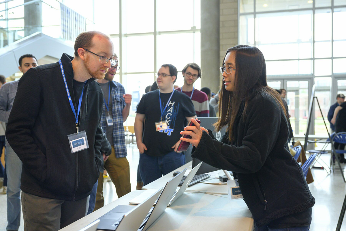 MTSU computer science assistant professor Josh Phillips, left, listens as Jessica Wijaya, a junior computer science major, explains her team’s project during the science fair portion of the fifth annual HackMT at MTSU, which concluded Sunday, Jan. 26, in the Science Building’s Liz and Creighton Rhea Atrium. (MTSU photo by Cat Curtis Murphy)