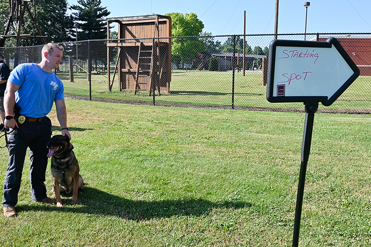 Sgt. Zachery Brooker, Middle Tennessee State University Police K-9 handler, pets his fetching partner Bobby, MTSU Police K-9 officer, as the two wait to run the narcotics-locating competition course at the Campus Recreation Center, part of the National Narcotic Detector Dog Association conference the department and university hosted earlier this month. (MTSU photo by Stephanie Wagner)