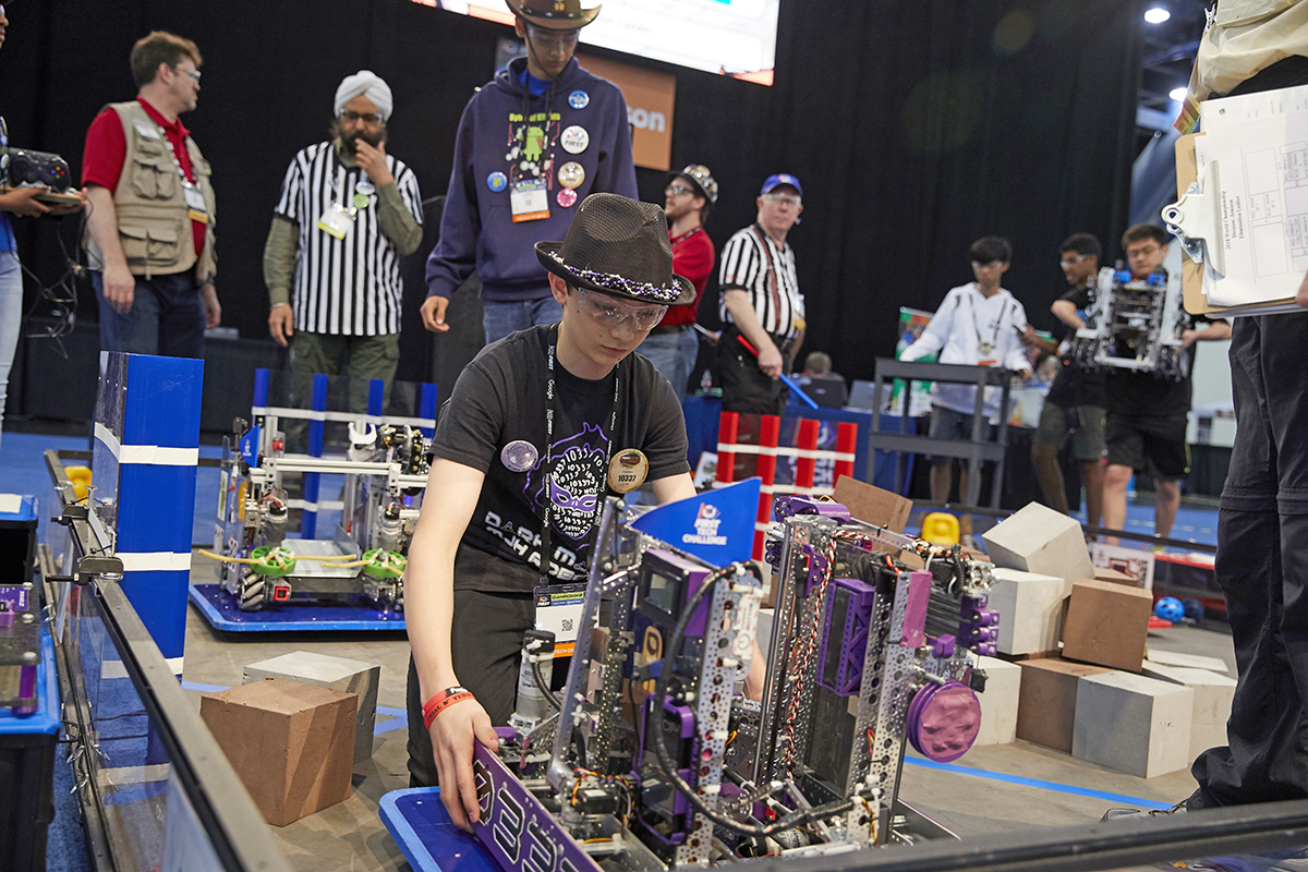 A participant lifts his team's robot.