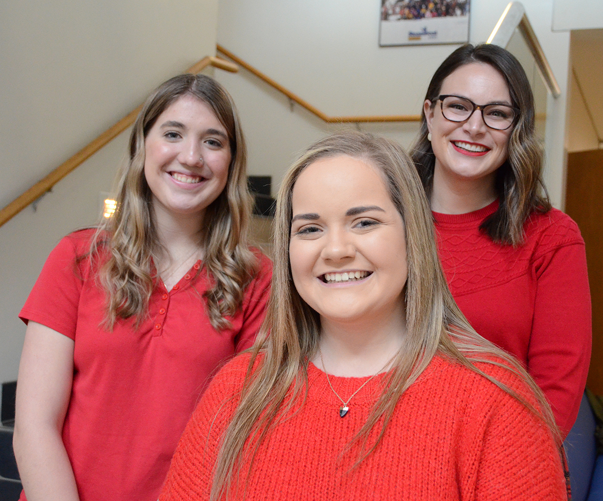 Freshmen Hannah Daigle, left, and Emily Hasty and university development officer Trisha Murphy pause for a photo during MTSU's annual National Wear Red Day activity Feb. 7 on campus. The trio, who were saluted by the university, were born with or developed heart conditions at an early age. (MTSU photo by Randy Weiler)