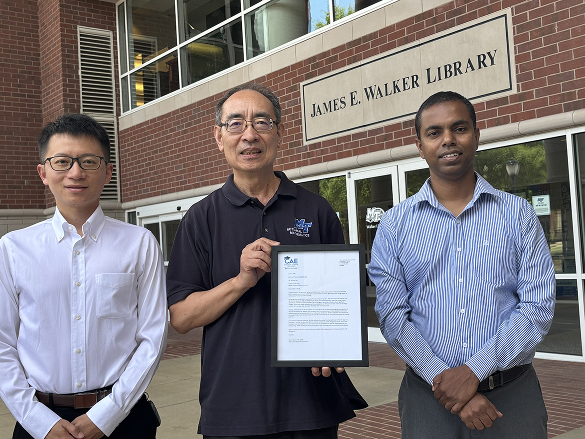 Pictured, from left, outside the James E. Walker Library at Middle Tennessee State University in Murfreesboro, Tenn., actuarial science faculty members Lu Xiong, Don Hong and Vajira Manathunga are shown with the letter from the Society of Actuaries Center of Actuary committee recognizing MTSU as a Center of Actuarial Science, making it one of the top programs in the world. (MTSU photo by Randy Weiler)