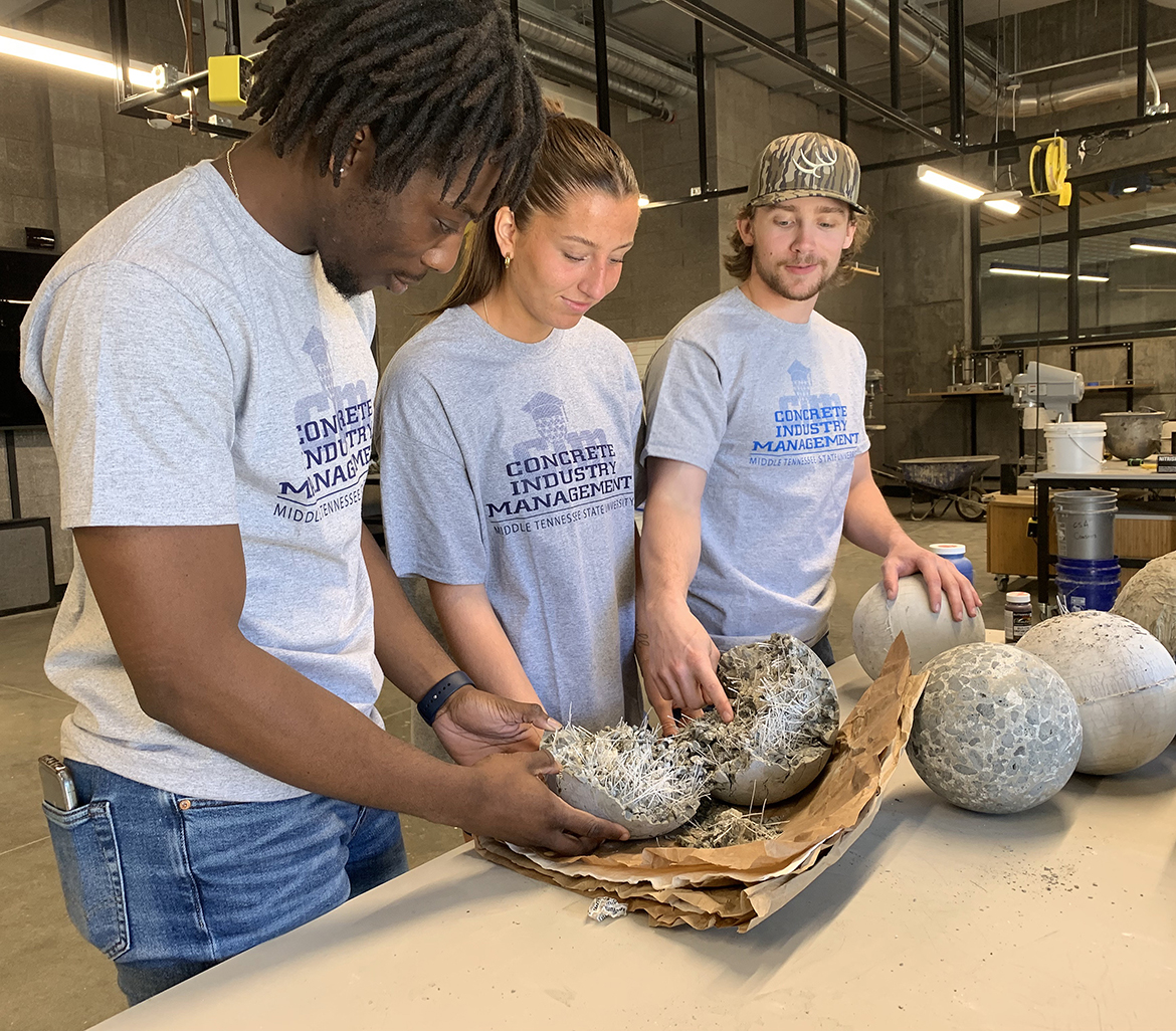 From left, Middle Tennessee State University Concrete Industry Management students Tyler Dixon, Ashley Gates and Joe Bell — all from Murfreesboro — check the fiber content of a concrete bowling ball they made and tested for the upcoming international competition a group of six students will compete in Sunday, April 2, in San Francisco, Calif., during the ACI Convention. The upper division class made the balls in the new CIM laboratory in the 54,000-square-foot School of Concrete and Construction Management Building, which opened in October. (MTSU photo by Randy Weiler)