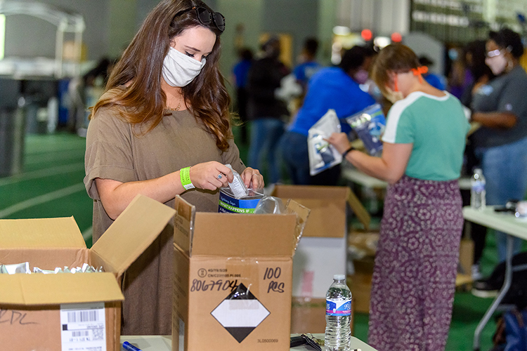 Bekah Juergens was among MTSU student, faculty and staff volunteers working Friday, Aug. 21, on the track of Murphy Center to assemble 5,000 COVID-19 care packages to distribute to student residence halls, academic colleges and high traffic areas. The graduate chapter of Alpha Kappa Alpha Inc. sorority partnered with the university to create the packages, which contained sanitizing items, masks and FAQ booklets about coronavirus precautions. (MTSU photo by J. Intintoli)